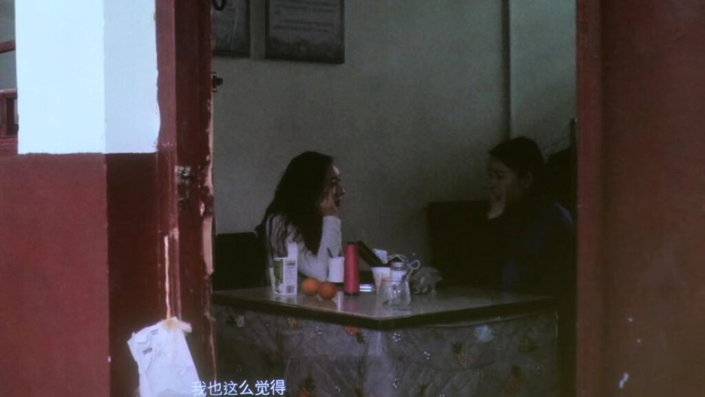 Xu sits with Hu Xin, the youngest teacher of Nüshu at the Nüshu Musem in Jiangyong. Still from Xu’s documentary film, “Outside Women’s Café (2023).” Image courtesy of the artist.