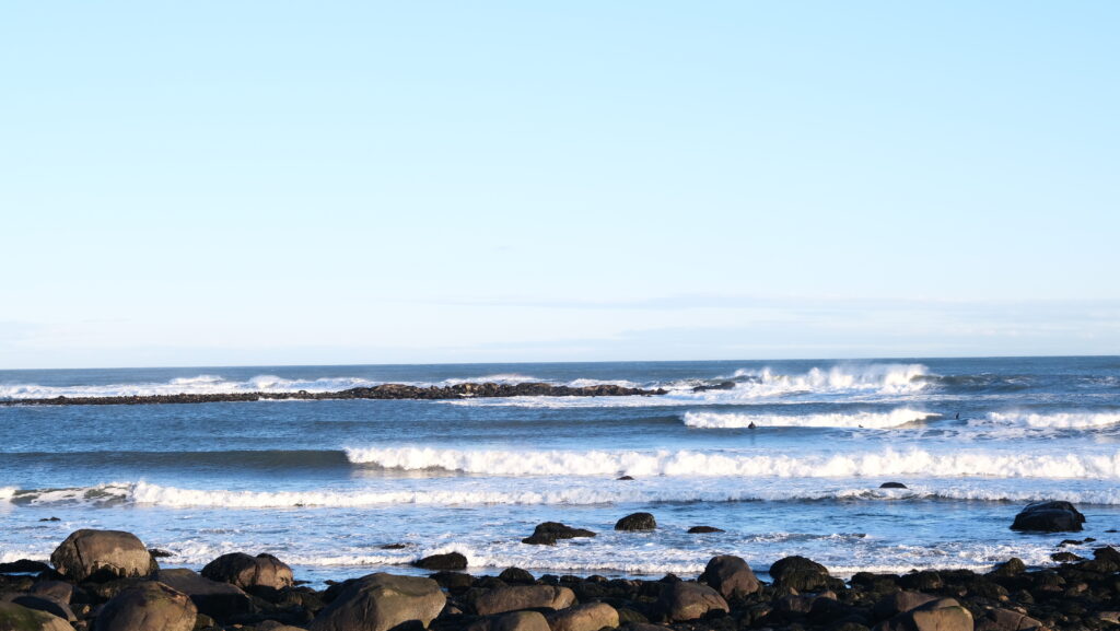 The ocean's waves hitting rocks on a shoreline. 