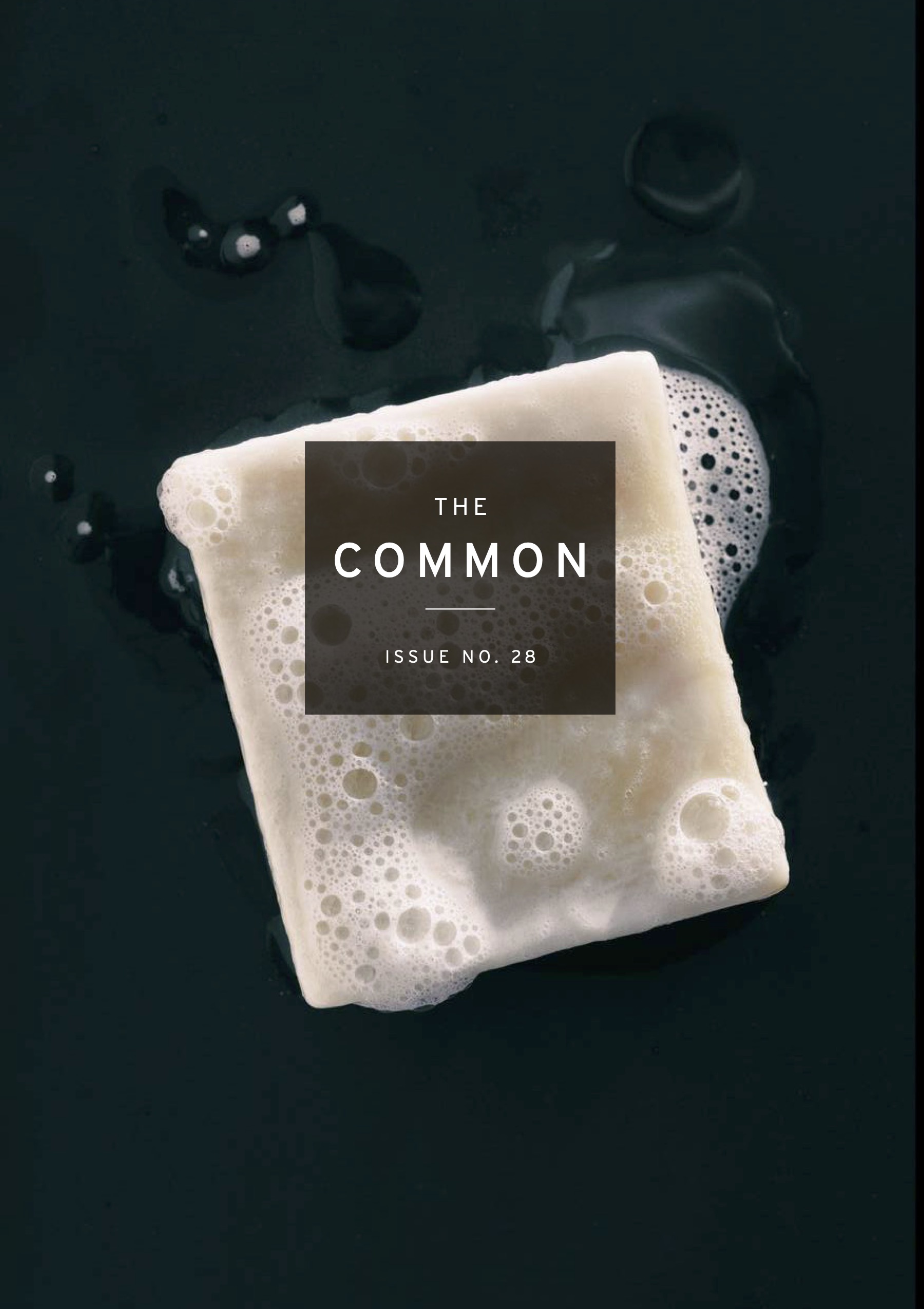 The Common Issue 28 Cover: very dark blue-green-black background with white bar of soap and white suds