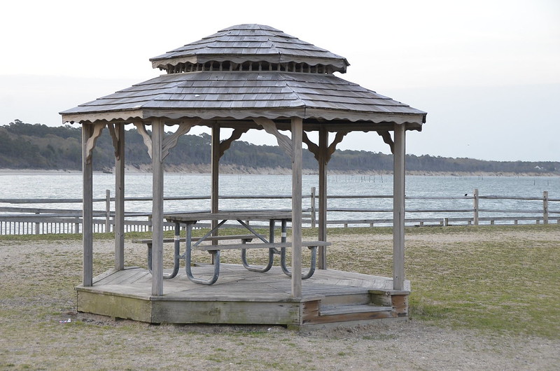 The sea in the horizon with a wooden gazebo.