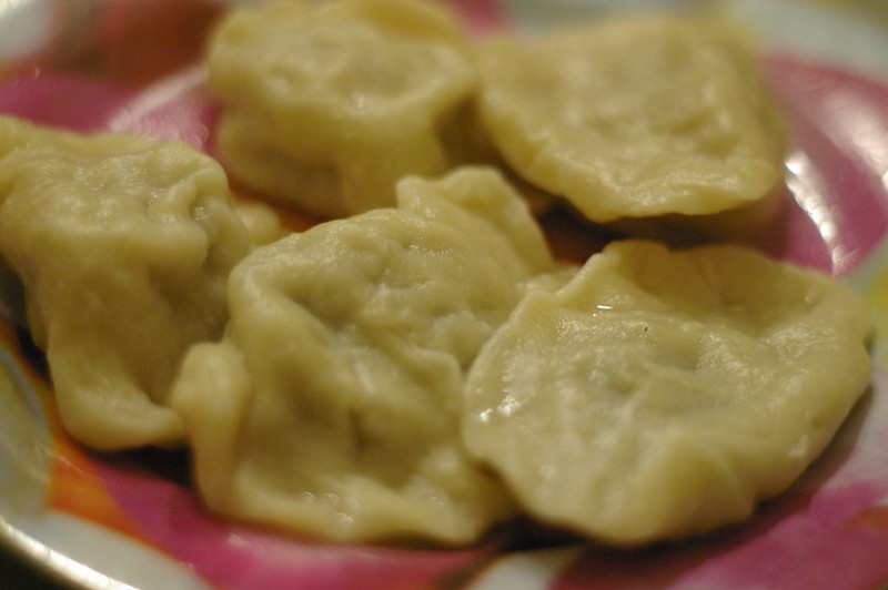 Polish dumplings on a red plate with a slightly blurred background.