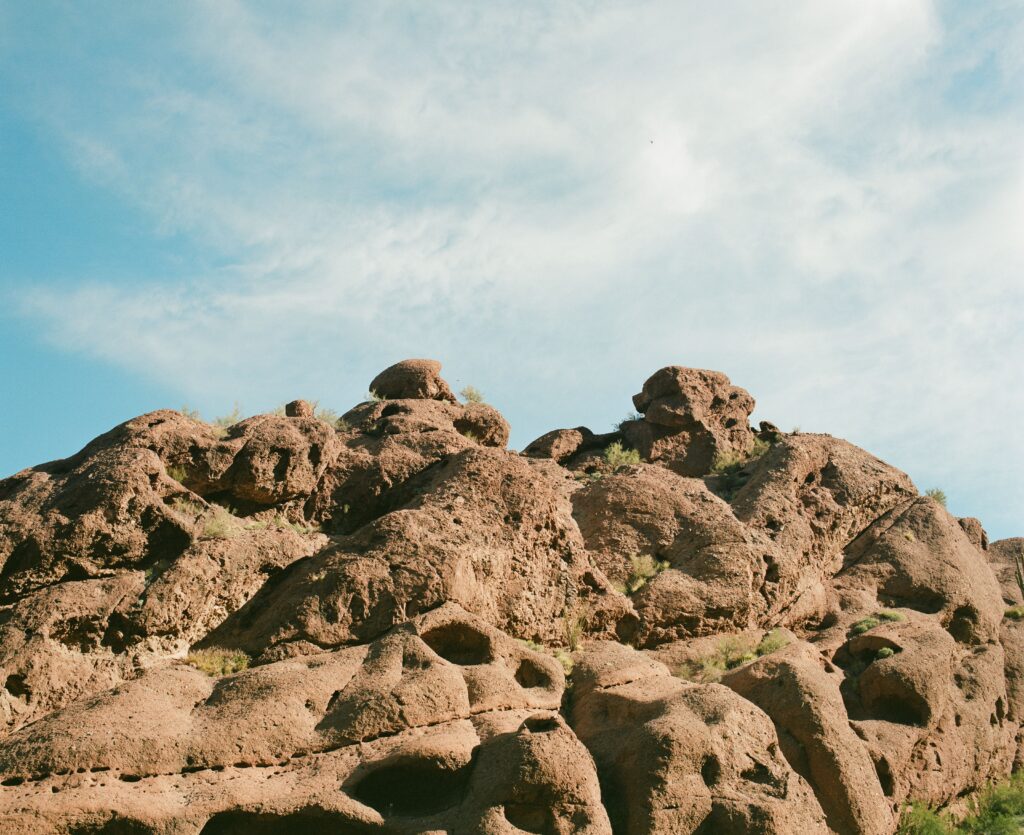 A mountainous terrain in Arizona with a cloudy blue sky in the background