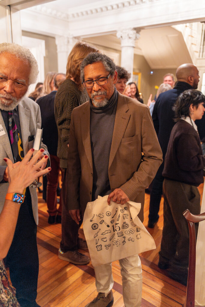 Everett smiling holding a TC tote bag.