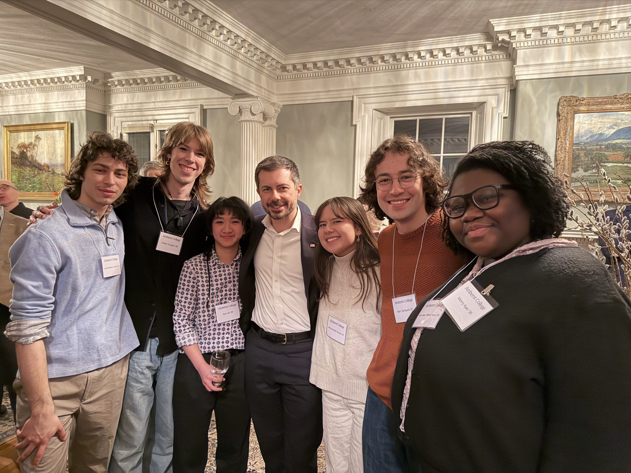 Seven people pose for a group photo inside a parlor.
